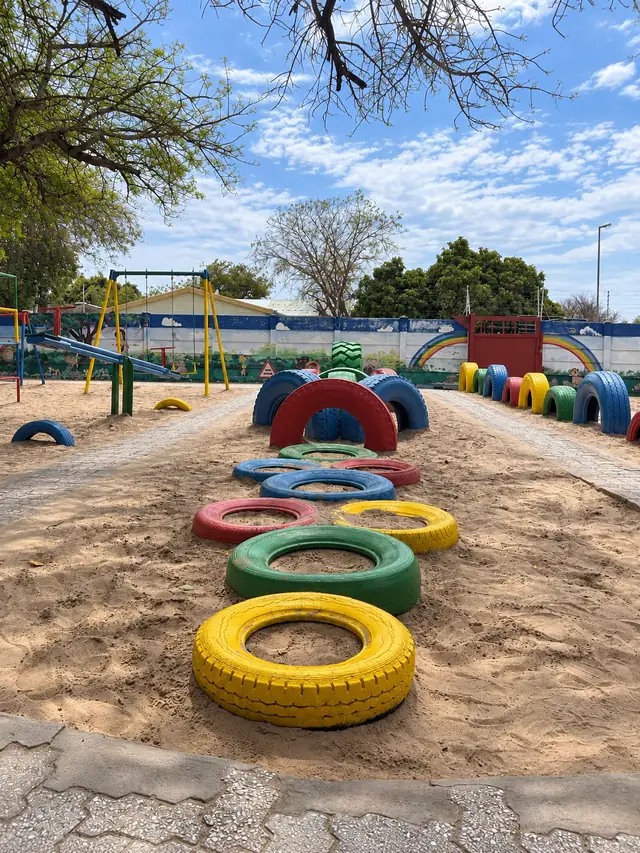 Rows of brightly painted tyres in the sandpit at our Ongwediva campus playground.